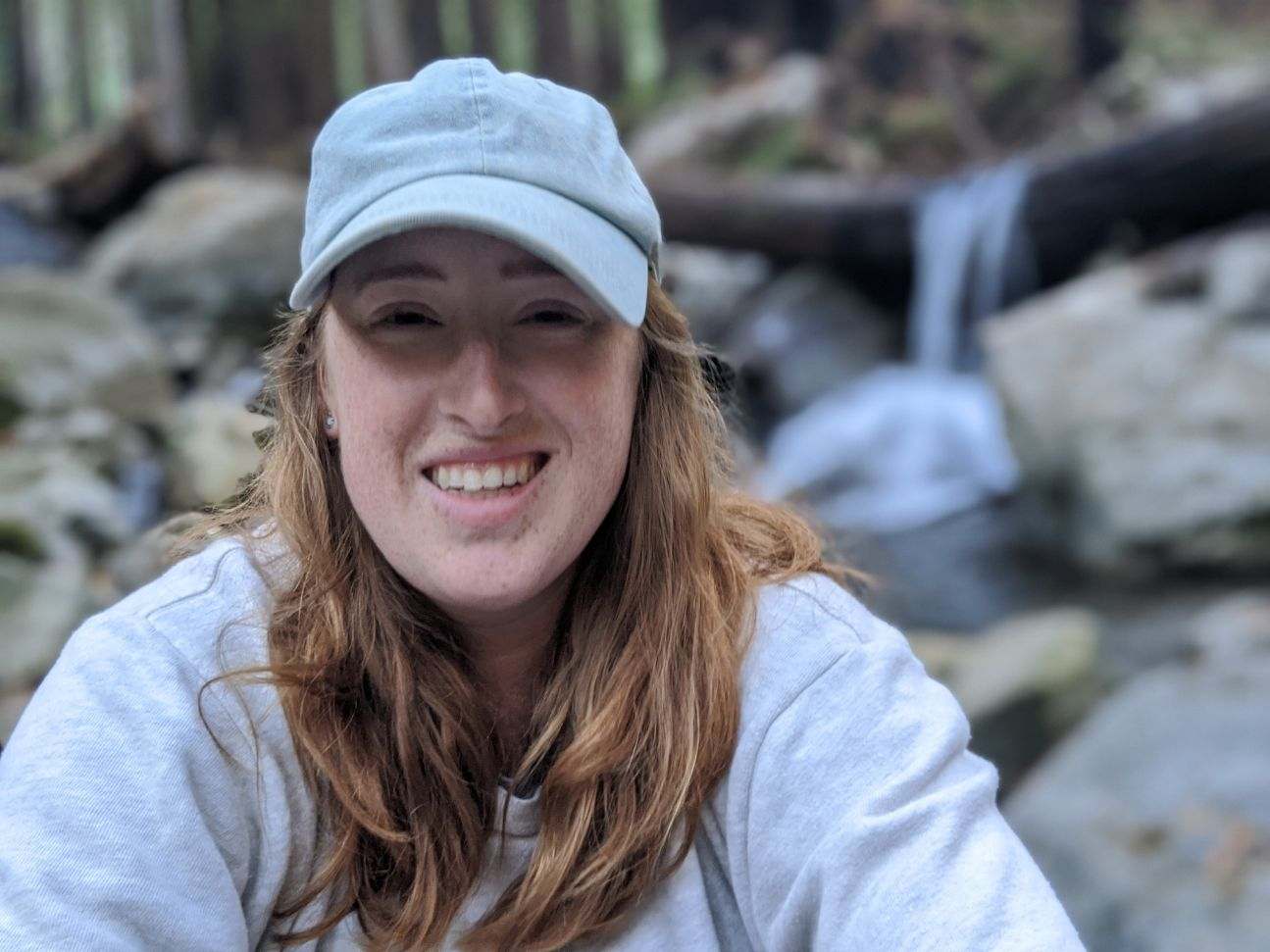 Bowerbird Field School founder Paige Baur outdoors near a waterfall